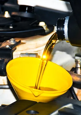 Engine oil being poured into a vehicle engine